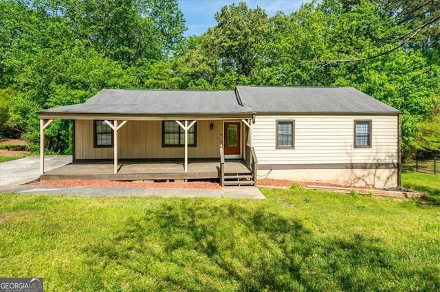 view of front facade featuring a carport, a front lawn, and covered porch