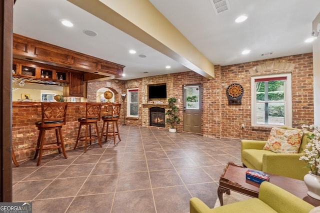 2551 Raintree Dr NE, Atlanta, GA 30345 - living room featuring beamed ceiling, dark tile patterned floors, visible vents, and brick wall