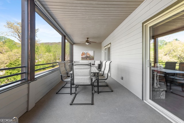 sunroom with ceiling fan, a wealth of natural light, and outdoor dining space