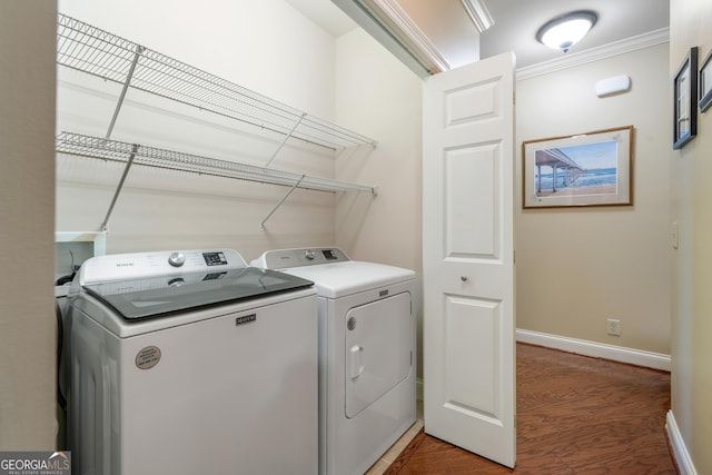 washroom with crown molding, light wood finished floors, washing machine and dryer, baseboards, and laundry area