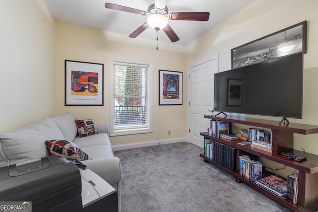 living area featuring carpet floors, a ceiling fan, and baseboards