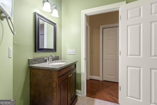 bathroom with baseboards, tile patterned floors, and vanity