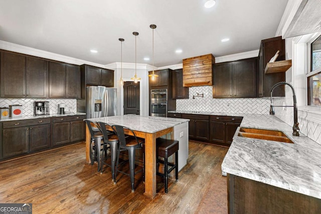 kitchen featuring a sink, tasteful backsplash, dark brown cabinetry, open shelves, and appliances with stainless steel finishes