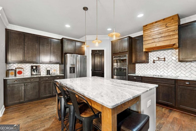 kitchen featuring decorative backsplash, dark brown cabinetry, appliances with stainless steel finishes, ornamental molding, and light stone countertops