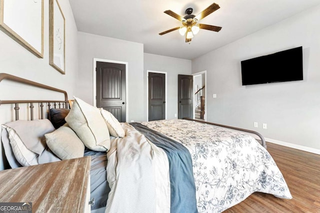 bedroom featuring wood finished floors, baseboards, and ceiling fan