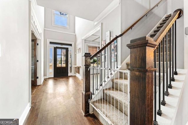 foyer entrance with stairway, baseboards, and wood finished floors