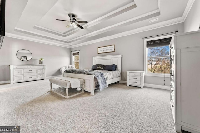 carpeted bedroom featuring baseboards, a tray ceiling, ceiling fan, and crown molding