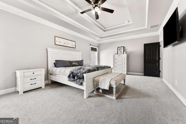 carpeted bedroom with visible vents, baseboards, a ceiling fan, and a tray ceiling