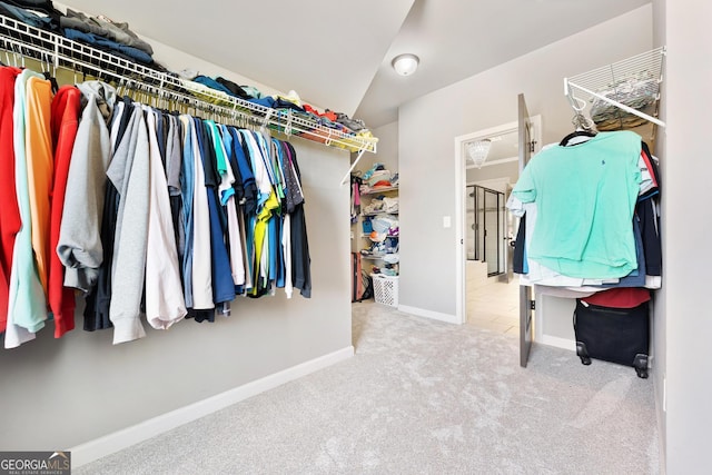 spacious closet with vaulted ceiling and carpet floors
