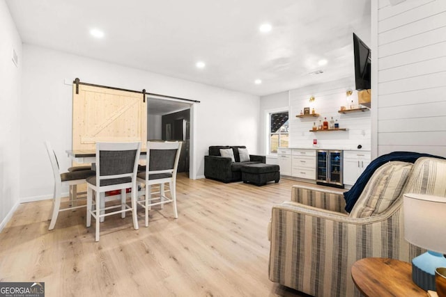 living room featuring recessed lighting, a dry bar, wine cooler, and light wood-type flooring