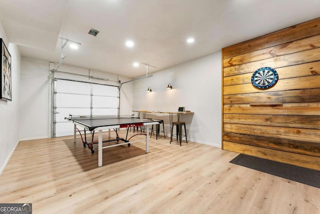 recreation room with recessed lighting, wood finished floors, baseboards, and a garage