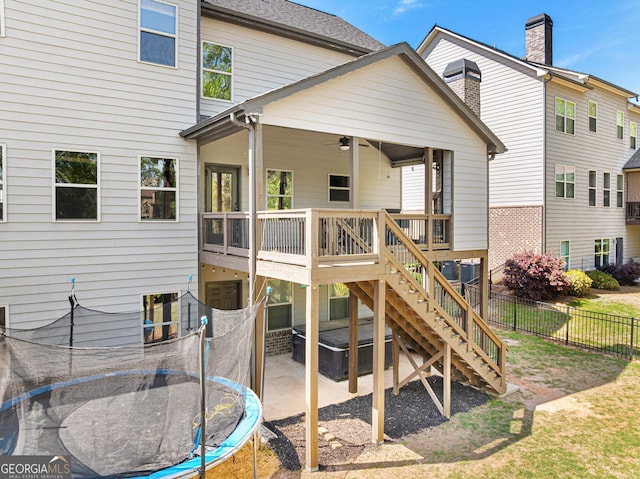 back of house featuring a trampoline, fence, a patio, stairs, and ceiling fan