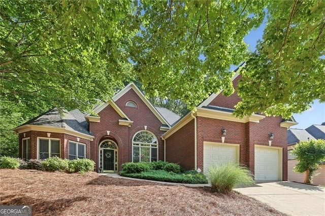 traditional home with an attached garage, brick siding, and concrete driveway