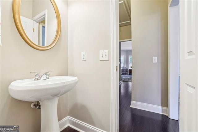 bathroom with baseboards and wood finished floors