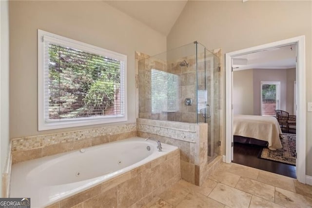 ensuite bathroom featuring a jetted tub, a stall shower, vaulted ceiling, and tile patterned flooring