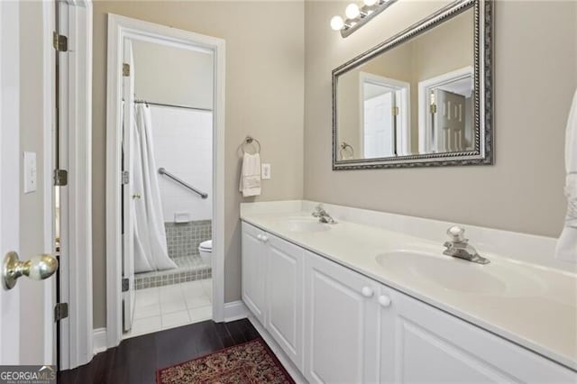full bathroom featuring toilet, wood finished floors, double vanity, and a shower with curtain
