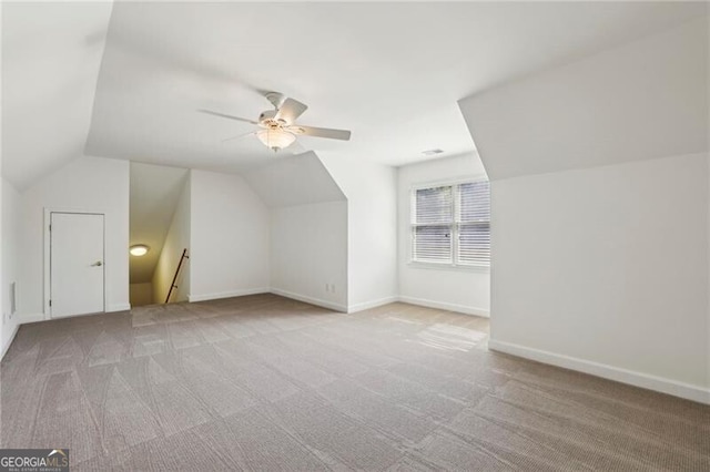 bonus room with light colored carpet, lofted ceiling, ceiling fan, and baseboards