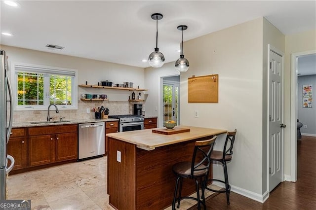 72 Griggs St SW, Marietta, GA 30064 - kitchen featuring stainless steel appliances, decorative backsplash, a peninsula, a kitchen breakfast bar, and healthy amount of natural light