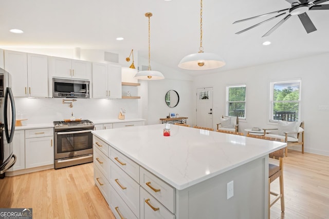 369 Arnold Mill Rd, Woodstock, GA 30188 - kitchen featuring a breakfast bar, light wood finished floors, stainless steel appliances, lofted ceiling, and a kitchen island