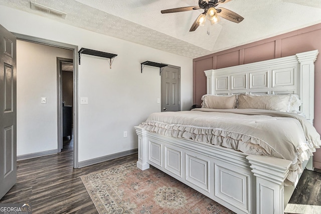 bedroom featuring visible vents, baseboards, wood finished floors, and a textured ceiling