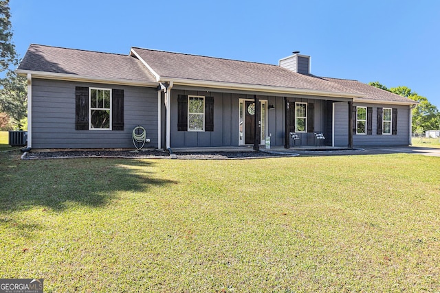 ranch-style home with a chimney, central AC unit, board and batten siding, a porch, and a front yard