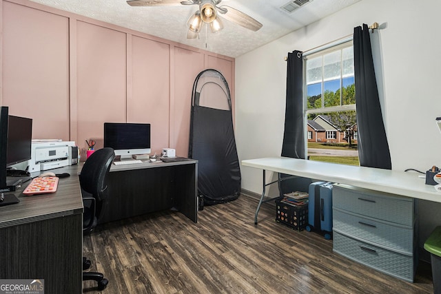 office area with a textured ceiling, ceiling fan, visible vents, and dark wood-style flooring