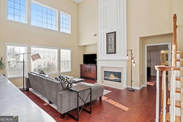 3125 Crooked Stick Dr, Cumming, GA 30041 - living area featuring dark wood finished floors, a high ceiling, a healthy amount of sunlight, and a large fireplace