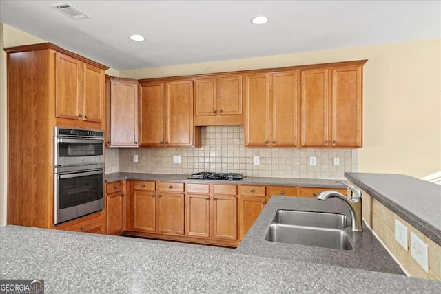 3125 Crooked Stick Dr, Cumming, GA 30041 - kitchen with stainless steel double oven, visible vents, gas cooktop, a sink, and decorative backsplash