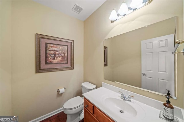 3125 Crooked Stick Dr, Cumming, GA 30041 - half bath with wood finished floors, visible vents, toilet, vanity, and baseboards