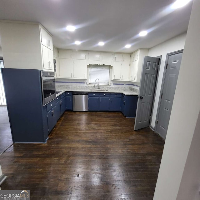 2704 Terratim Ln, Decatur, GA 30034 - kitchen featuring blue cabinetry, appliances with stainless steel finishes, a sink, dark wood-style flooring, and white cabinetry