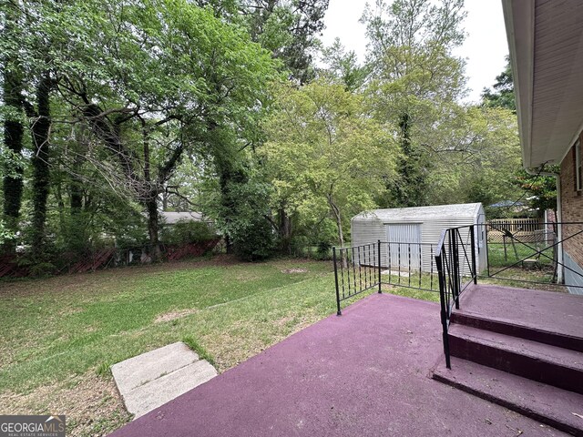 7336 Howard Cir, Jonesboro, GA 30236 - view of yard featuring fence, a patio area, an outbuilding, and a storage shed