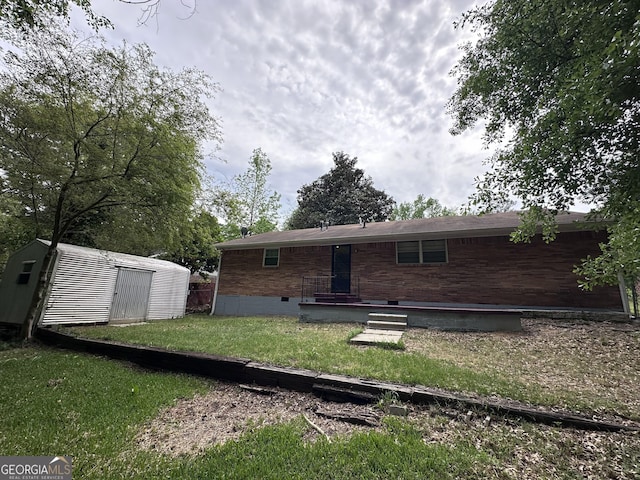 7336 Howard Cir, Jonesboro, GA 30236 - back of property featuring crawl space, a shed, an outdoor structure, a yard, and brick siding