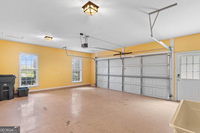 garage featuring a sink, a garage door opener, and baseboards