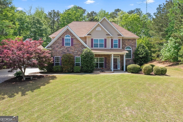 craftsman-style home with a porch, a front yard, and stone siding