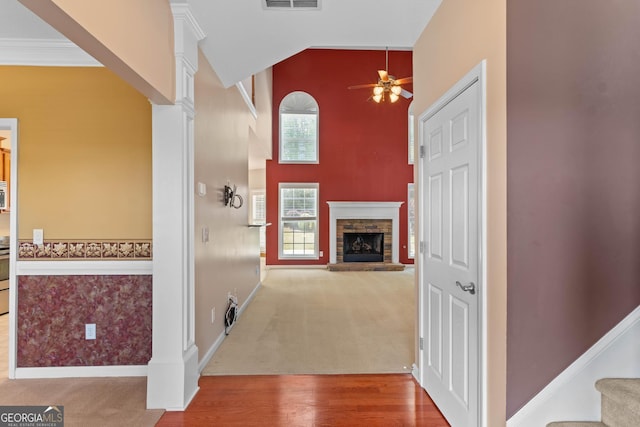 corridor featuring stairway, visible vents, carpet floors, decorative columns, and high vaulted ceiling