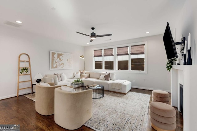 living room featuring dark wood-style floors, visible vents, recessed lighting, a ceiling fan, and a fireplace