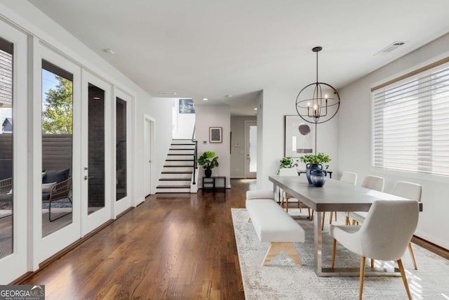 dining area with stairs, a chandelier, dark wood-type flooring, and visible vents