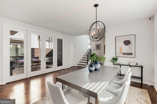 dining space with dark wood finished floors, stairs, french doors, and an inviting chandelier