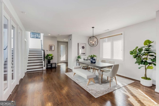 dining area featuring baseboards, dark wood-style floors, an inviting chandelier, and stairway