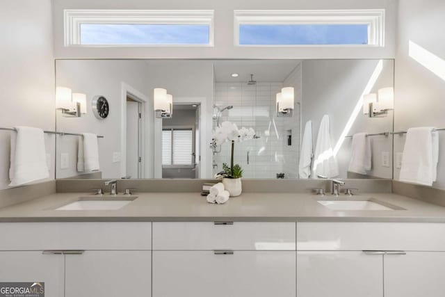 full bathroom with double vanity, a stall shower, and a sink
