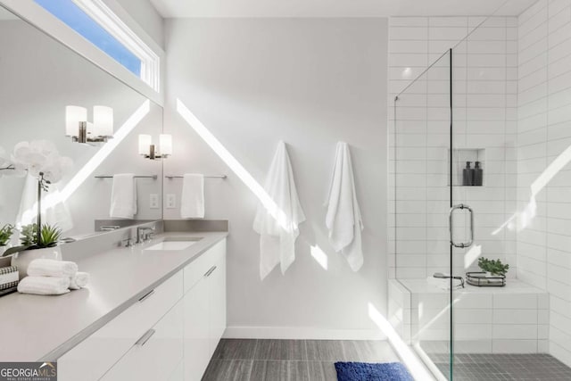 full bath with baseboards, tile patterned floors, vanity, and a stall shower