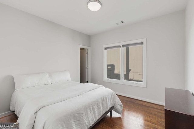 bedroom featuring dark wood-style floors, baseboards, and visible vents