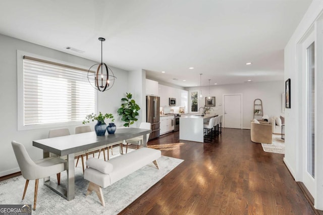 dining area featuring dark wood-style floors, an inviting chandelier, visible vents, and recessed lighting
