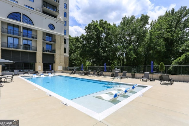 community pool featuring a patio area and fence