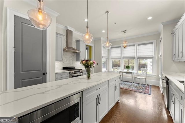 kitchen with wall chimney range hood, appliances with stainless steel finishes, recessed lighting, tasteful backsplash, and ornamental molding