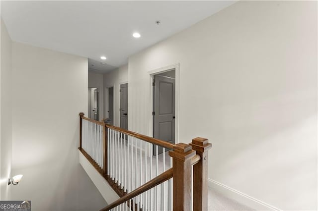hall with recessed lighting, carpet flooring, baseboards, and an upstairs landing