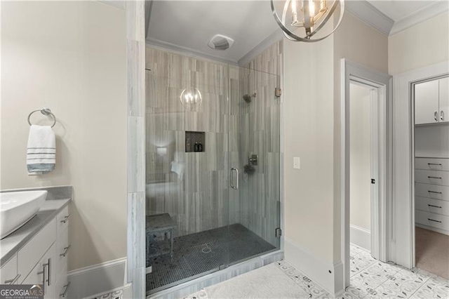 bathroom with an inviting chandelier, vanity, baseboards, ornamental molding, and a stall shower