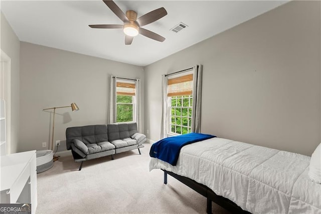 bedroom featuring baseboards, a ceiling fan, light colored carpet, and visible vents