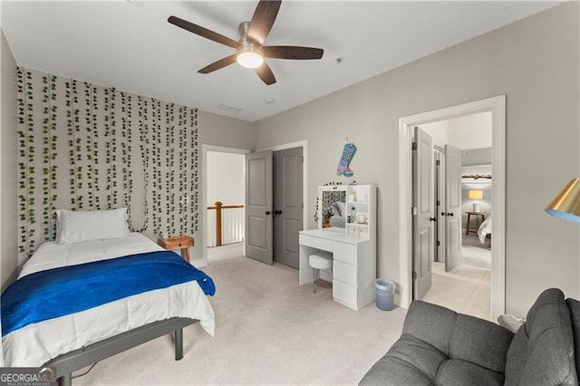 bedroom featuring light carpet and a ceiling fan