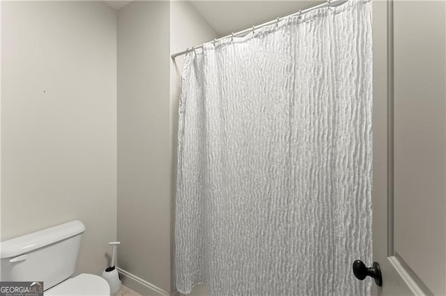 full bathroom with curtained shower and toilet